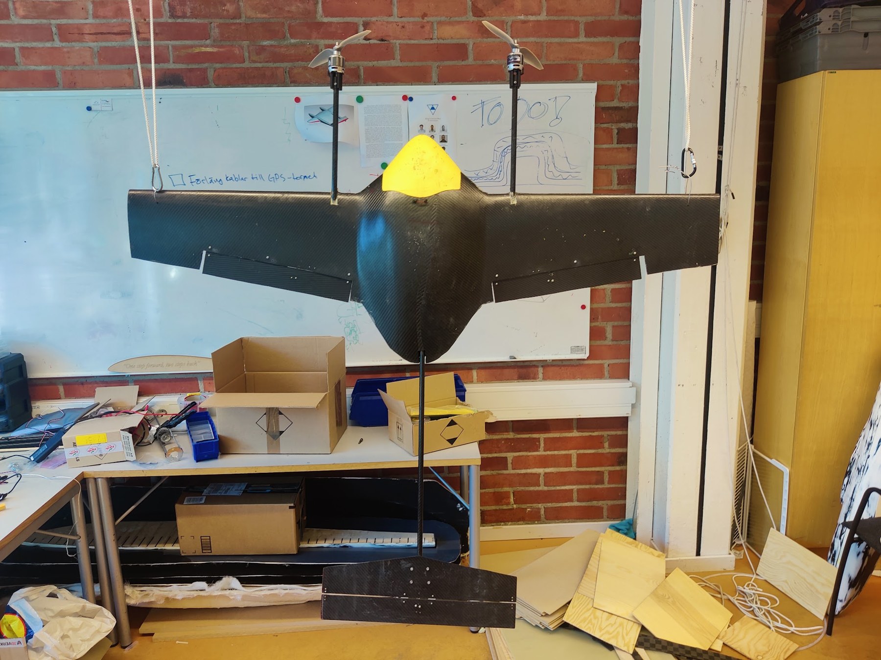 Petrel carbon-fibre aircraft prototype with a yellow nose and two elevated motors in the workshop